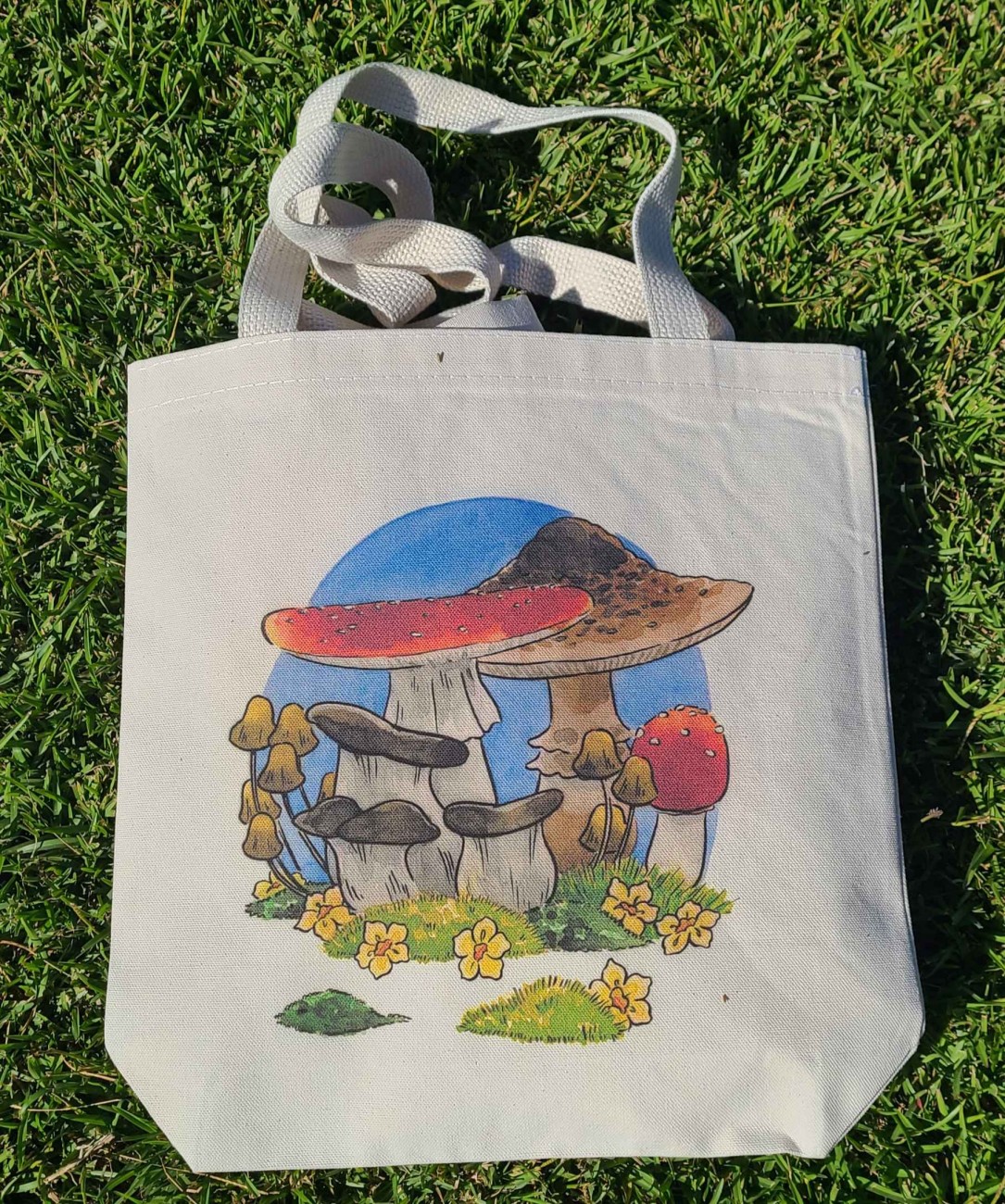 Natural canvas tote bag with my mushroom frog illustration printed across it.
