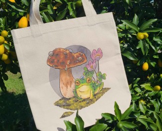 Natural canvas tote bag with my mushroom frog illustration printed across it.