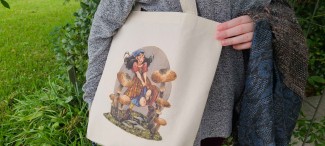 A natural cotton tote bag featuring a Renn Faire or fantasy inspired girl running through oversized mushrooms. She wears a kerchief and a plaid skirt, and her hair is floating behind her.