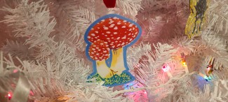 Fly agaric mushroom acrylic ornament in a white Christmas tree