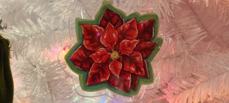 Red poinsettia ornament on a white Christmas tree